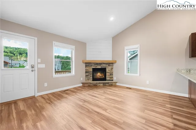 a view of empty room with wooden floor and fireplace