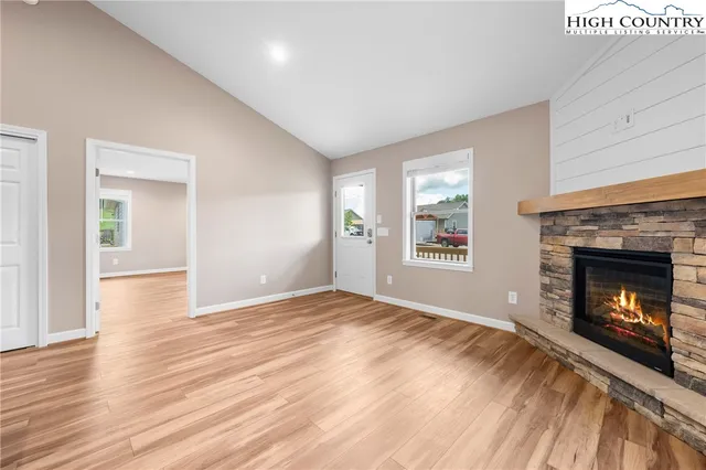 a view of an empty room with window and fire place