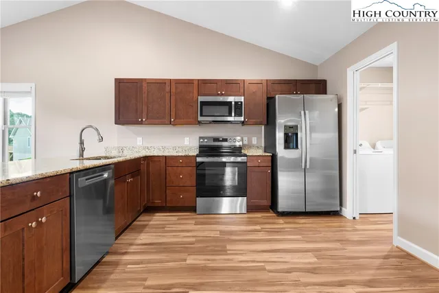 a kitchen with stainless steel appliances granite countertop a refrigerator and a stove top oven