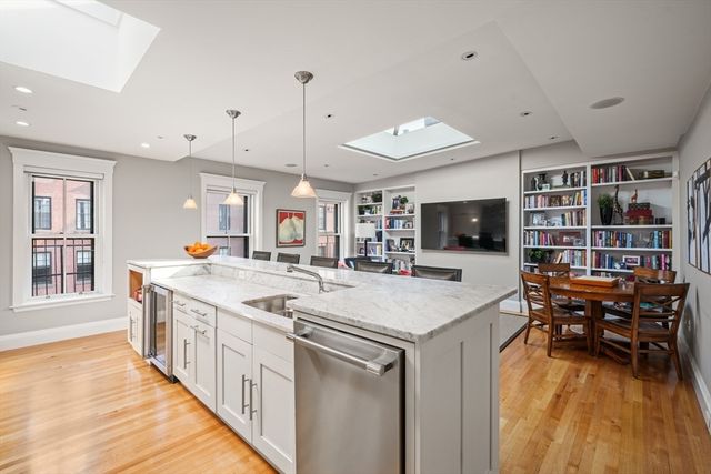 a large kitchen with kitchen island a sink a counter space and stainless steel appliances
