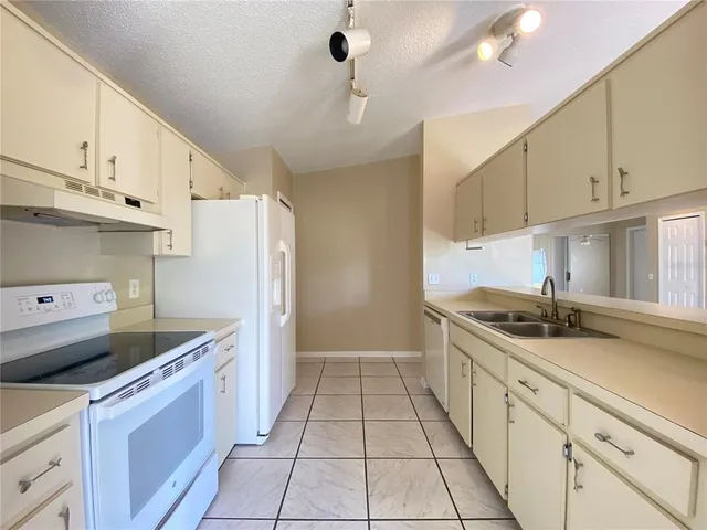 a kitchen with granite countertop a sink stove and cabinets