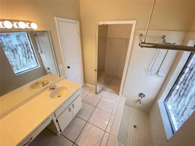 a bathroom with a tub sink and mirror