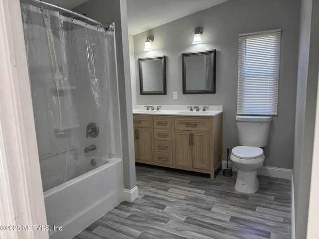 a bathroom with a granite countertop sink toilet a mirror and bathtub