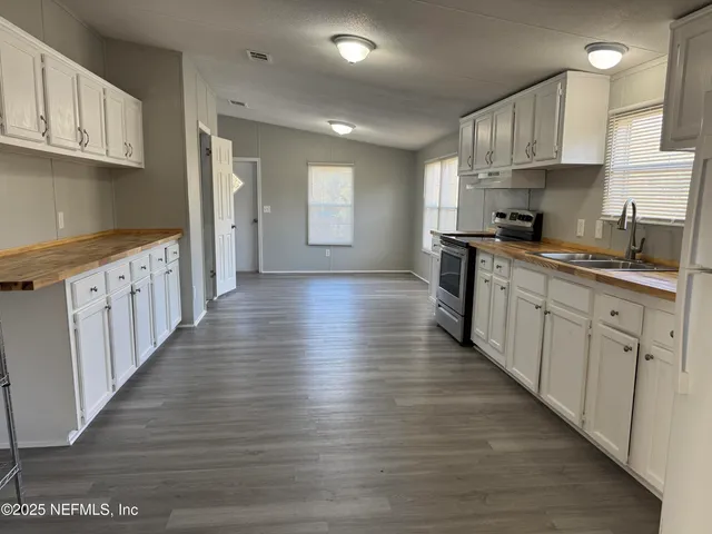 a kitchen with granite countertop a sink and cabinets