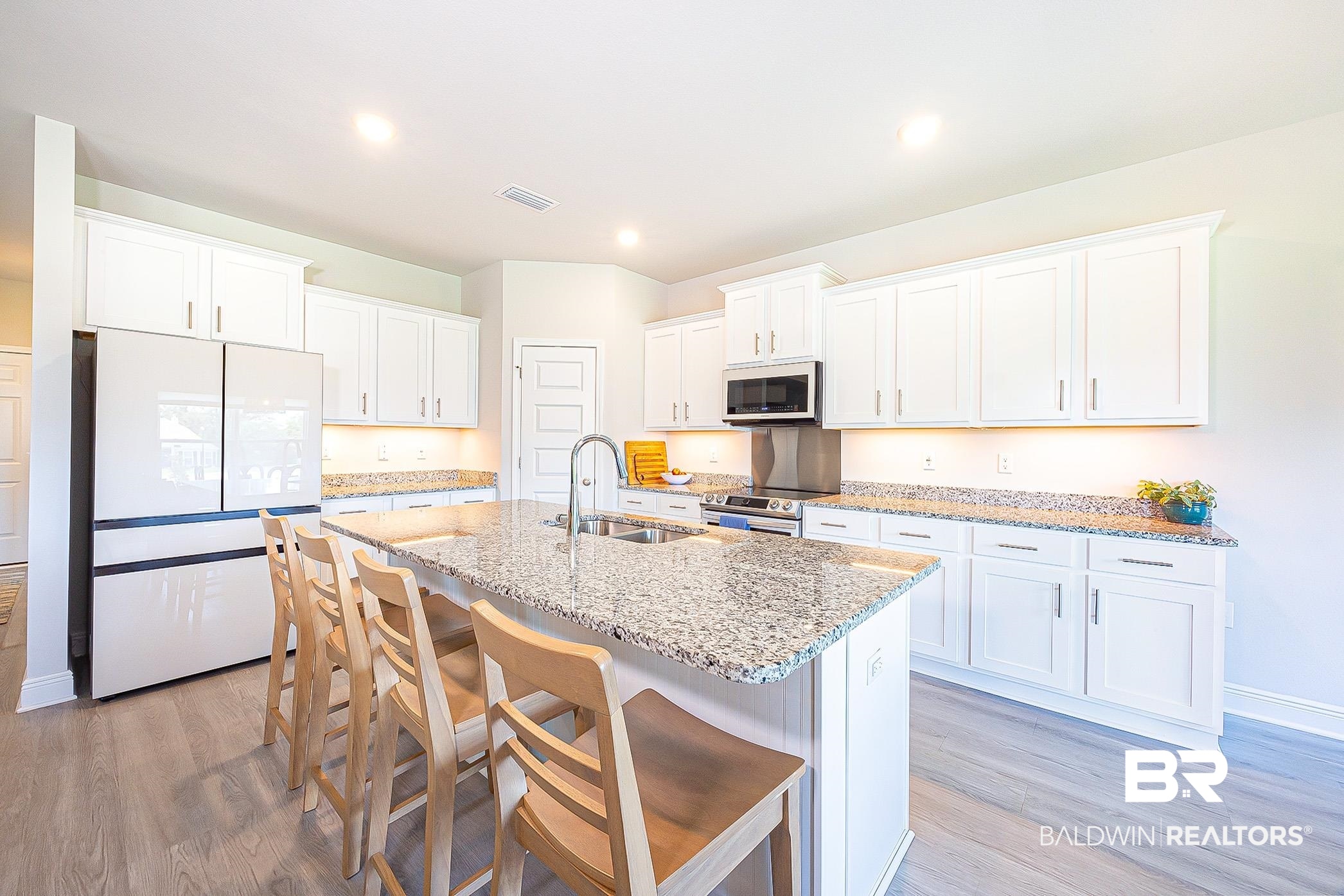 11044 Native Dancer Way Daphne, AL 36526 - Photo 12 of 67 Kitchen featuring appliances with stainless steel finishes, light hardwood / wood-style flooring, sink, and a kitchen island with sink