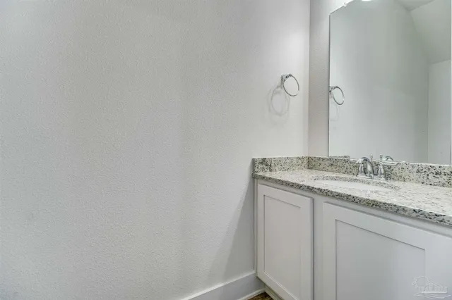 a bathroom with a granite countertop sink and vanity