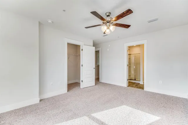 an empty room with a ceiling fan and window