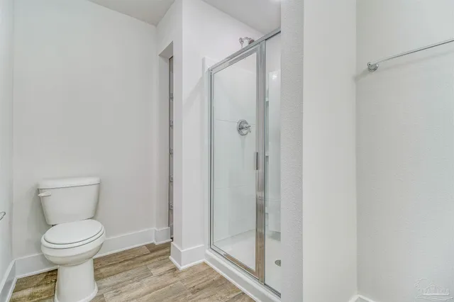 a bathroom with a toilet and a shower