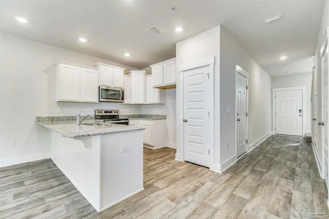 a kitchen with stainless steel appliances granite countertop a refrigerator and a stove top oven