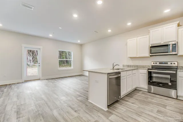 a kitchen with granite countertop a stove top oven and sink