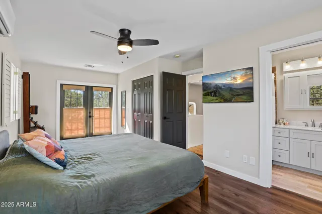 a bedroom with a bed and a large mirror with wooden floor