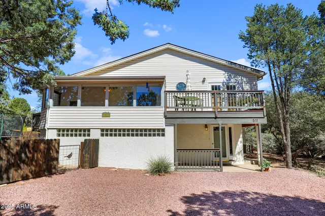 a view of a white house with large windows and a small yard