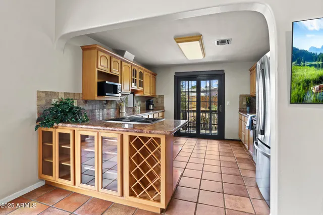 a kitchen with stainless steel appliances granite countertop a stove top oven a sink and a refrigerator