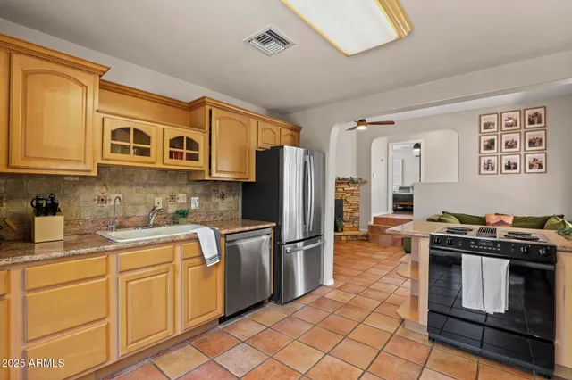 a kitchen with stainless steel appliances granite countertop a stove a sink dishwasher and a refrigerator