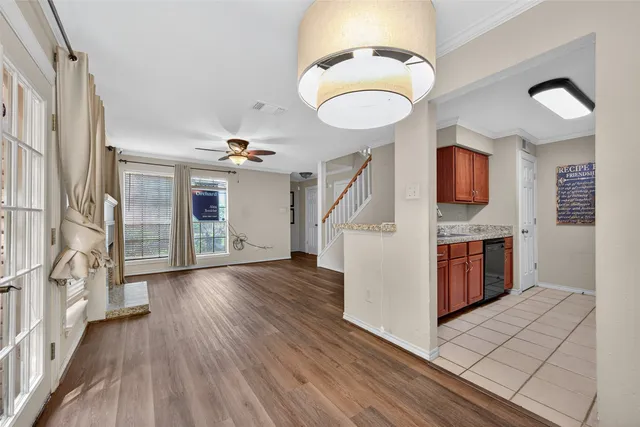 a view of a livingroom with wooden floor and a kitchen