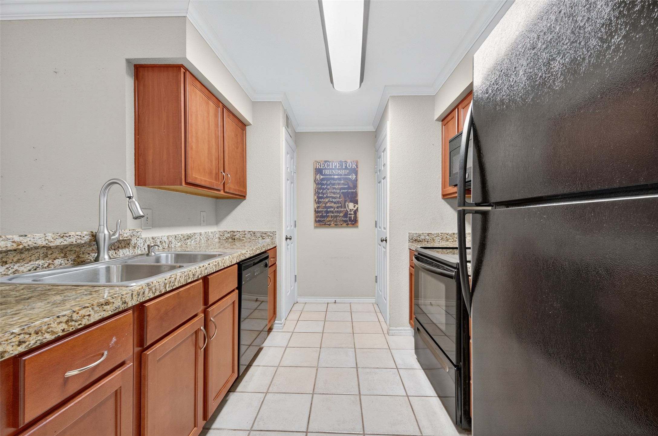 2211 South Kirkwood Road, Unit 49 Houston, TX 77077 - Photo 15 of 34 a kitchen with granite countertop a refrigerator and a sink