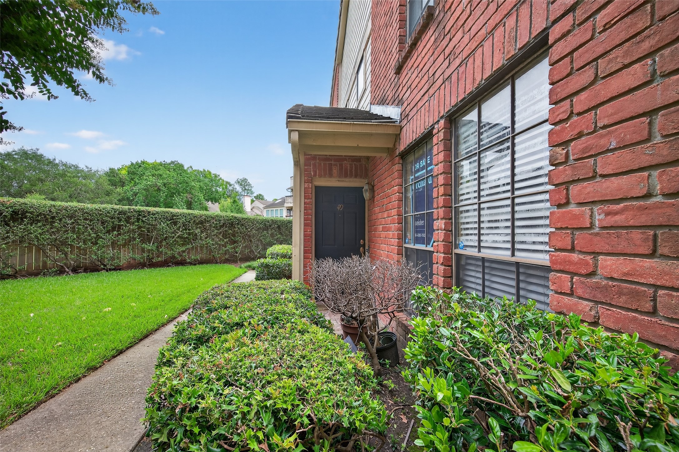 2211 South Kirkwood Road, Unit 49 Houston, TX 77077 - Photo 7 of 34 a front view of a house with a yard