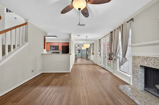a hallway with wooden floor fireplace and windows