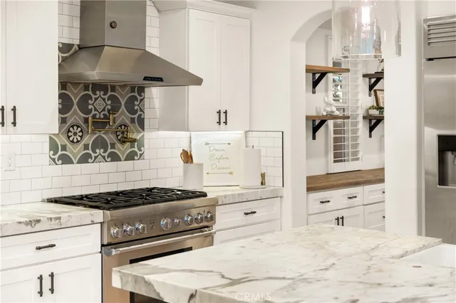 a kitchen with a stove and white cabinets