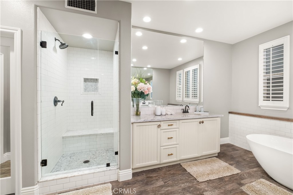 12 Ardennes Drive Ladera Ranch, CA 92694 - Photo 20 of 58 a bathroom with a granite countertop sink a mirror a bathtub and shower