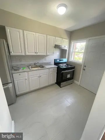 a kitchen with stainless steel appliances a stove a sink and a refrigerator