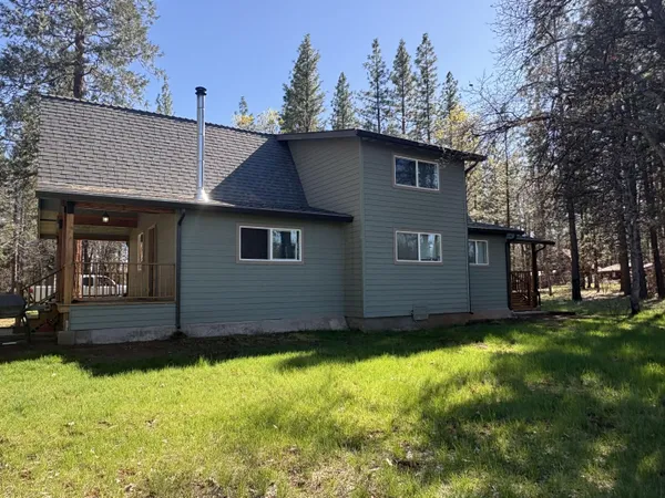 a view of a house with a small yard and wooden floor and fence