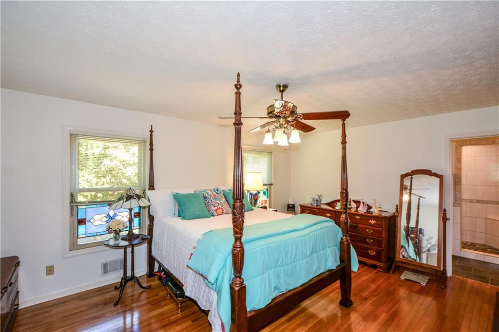 130 Hawn Road Fayetteville, GA 30215 - Photo 21 of 67 a bedroom with a bed a chandelier and wooden floor