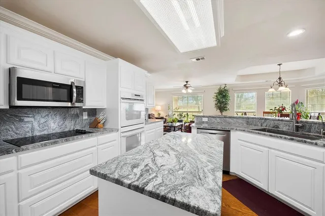 a kitchen with sink stove and microwave