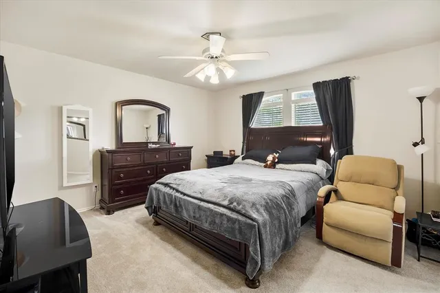 a bedroom with a bed and dresser with mirror