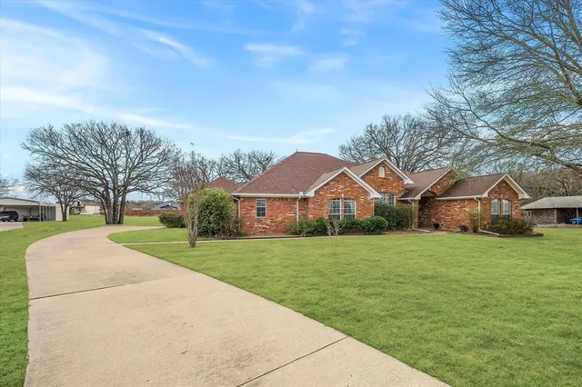 a front view of a house with yard and green space