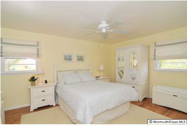 861 Colts Neck Road Freehold, NJ 07728 - Photo 13 of 25 a bedroom with a bed and a chandelier