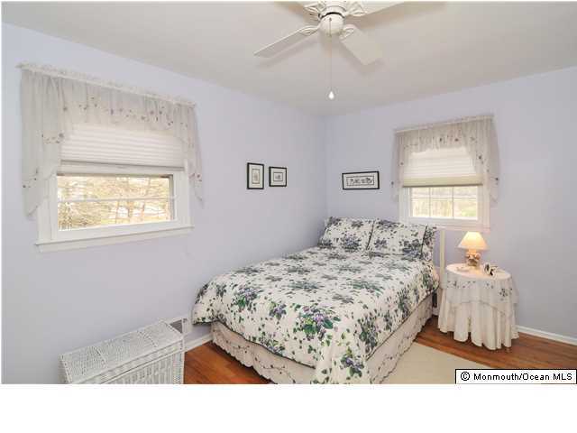 861 Colts Neck Road Freehold, NJ 07728 - Photo 17 of 25 a bedroom with a bed and a chandelier