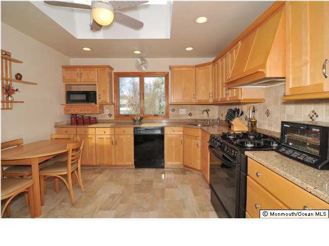861 Colts Neck Road Freehold, NJ 07728 - Photo 9 of 25 a kitchen with stainless steel appliances granite countertop a stove top oven a sink a counter space and cabinets