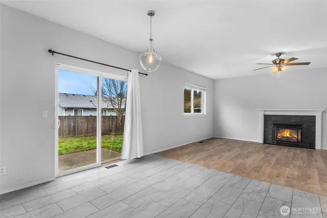 a view of an empty room with a fireplace and a window