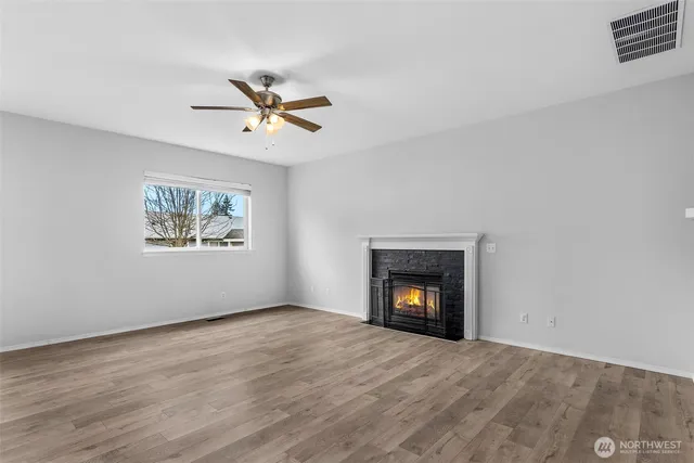 a view of an empty room with window and fireplace