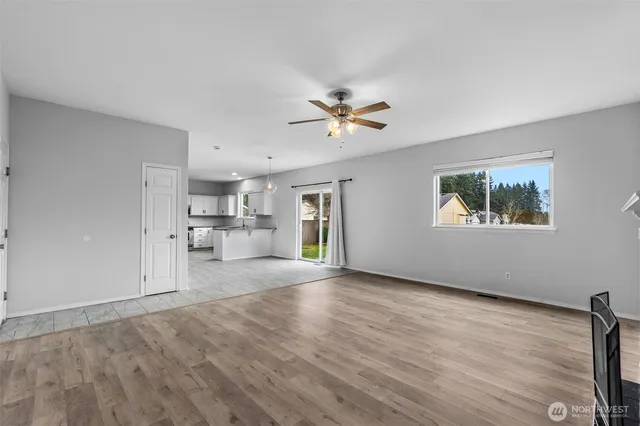 a view of empty room with wooden floor and window