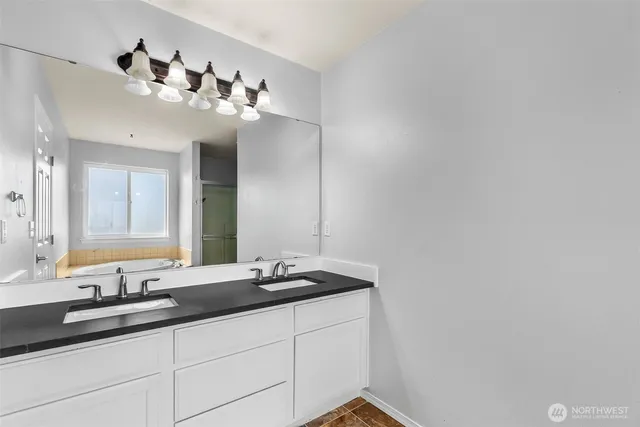 a bathroom with a double vanity sink and a mirror