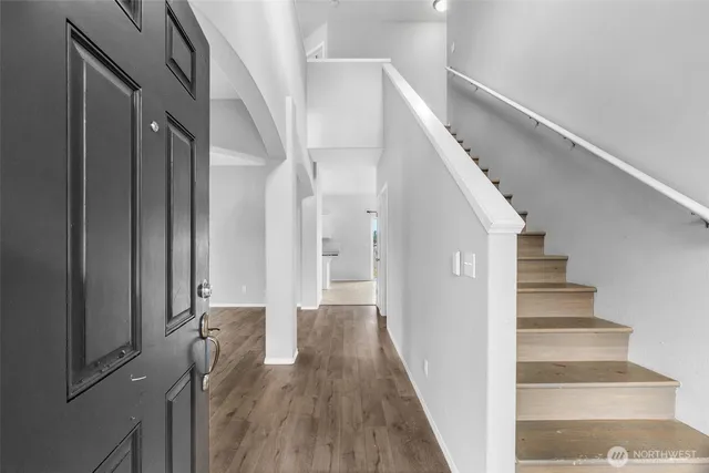 a view of a hallway with wooden floor and entryway