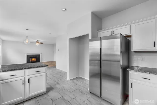 a kitchen with granite countertop a refrigerator and a sink