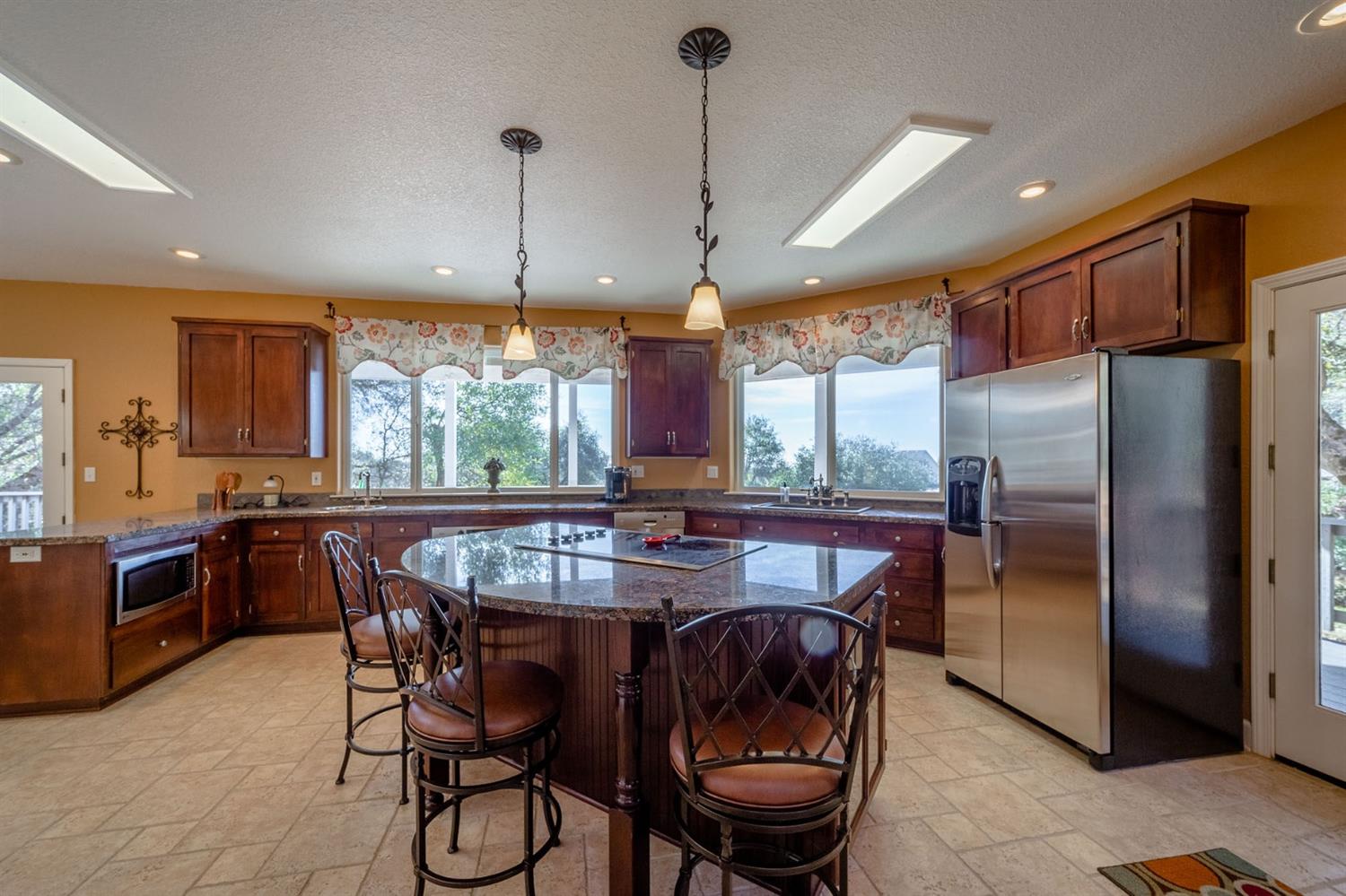 11545 Rocher Court Columbia, CA 95310 - Photo 3 of 49 a kitchen with stainless steel appliances granite countertop a stove a refrigerator a kitchen island a table and chairs