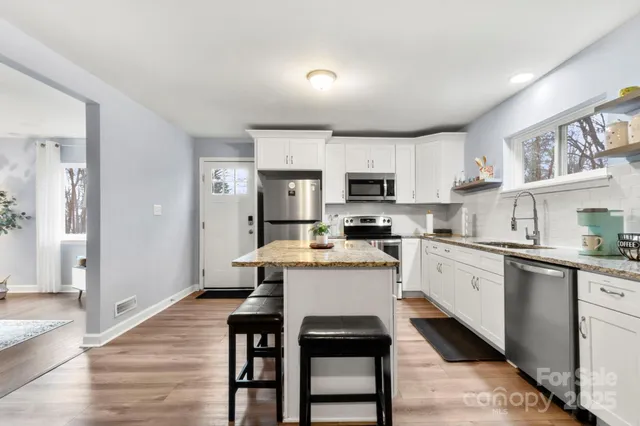 a kitchen with white cabinets and appliances