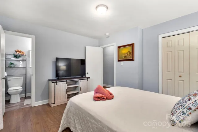 a bedroom with a bed and a flat screen tv