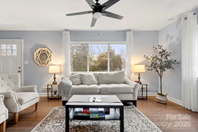 a living room with furniture a chandelier and a large window