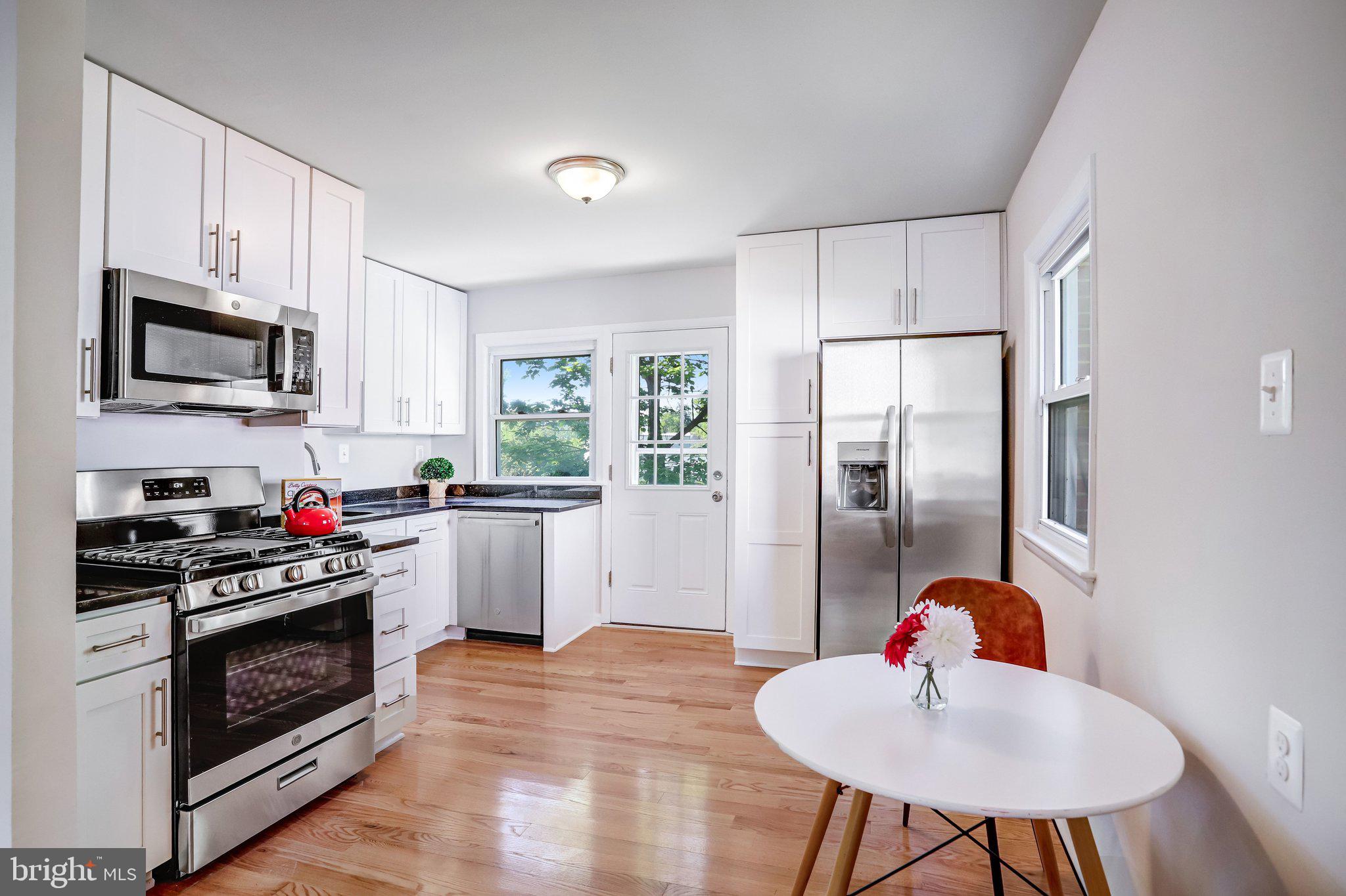 616 Ritchie Avenue Silver Spring, MD 20910 - Photo 6 of 37 a kitchen with stainless steel appliances kitchen island granite countertop a refrigerator a stove top oven a sink dishwasher and white cabinets with wooden floor