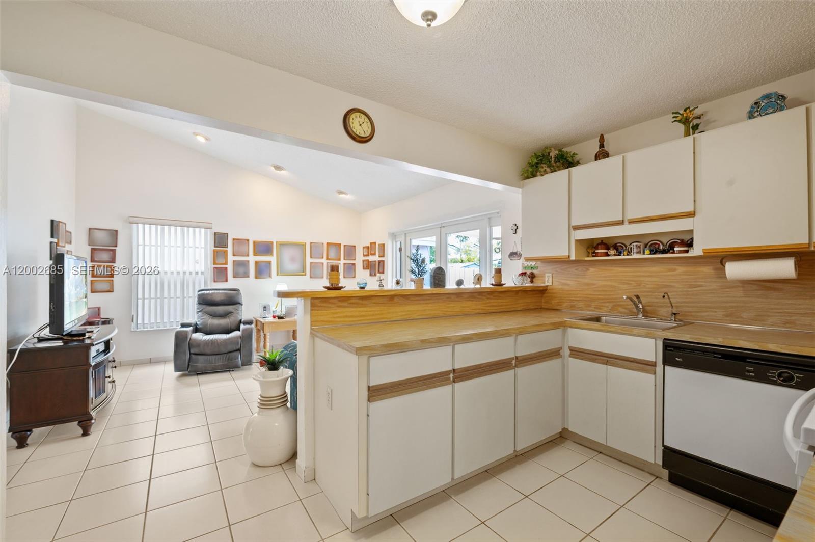 13440 Southwest 28th Street Miami, FL 33175 - Photo 11 of 35 a kitchen with a sink dishwasher stove and white cabinets