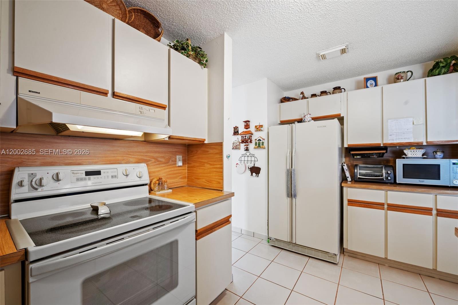13440 Southwest 28th Street Miami, FL 33175 - Photo 12 of 35 a kitchen with appliances a refrigerator and a stove top oven