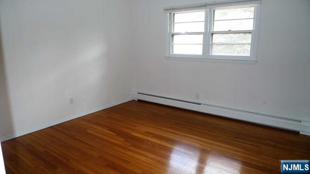 48 Rock Road Englewood Cliffs, NJ 07632 - Photo 17 of 23 an empty room with wooden floor and windows