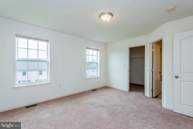 an empty room with windows and closet