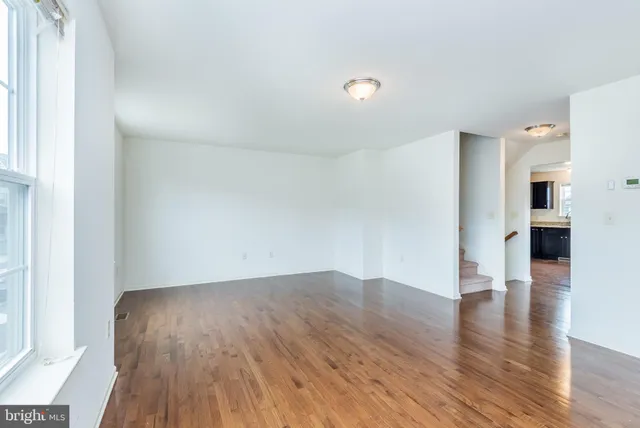 an empty room with wooden floor and a window