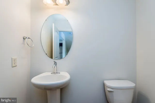 a bathroom with a toilet a sink and mirror
